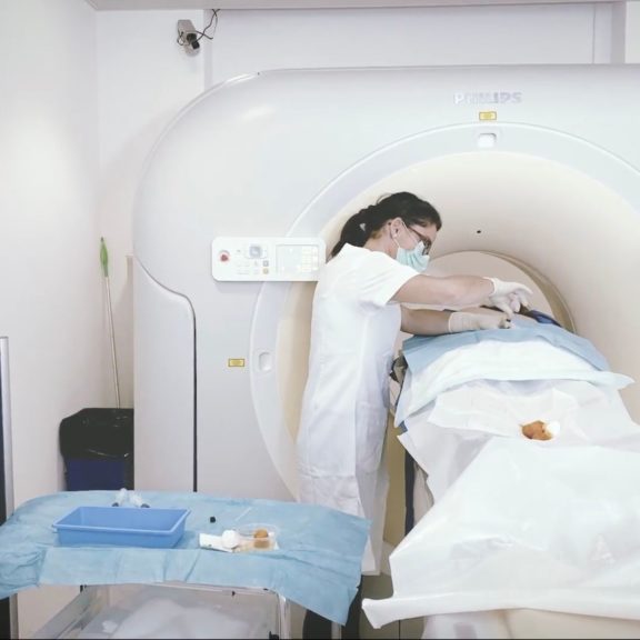 Médecin radiologue en train d'effectuer une infiltration thérapeutique sous contrôle scanner pour soulager une névralgie pudendale