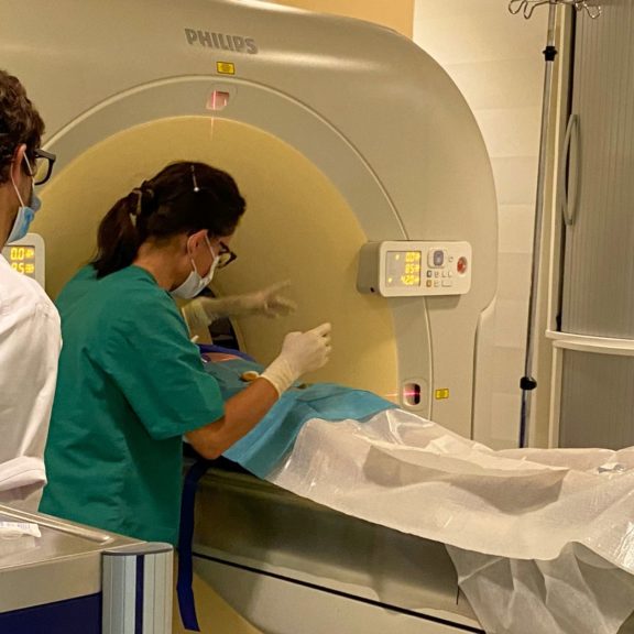 Médecin radiologue en train d'effectuer une infiltration thérapeutique pour soulager une lombalgie